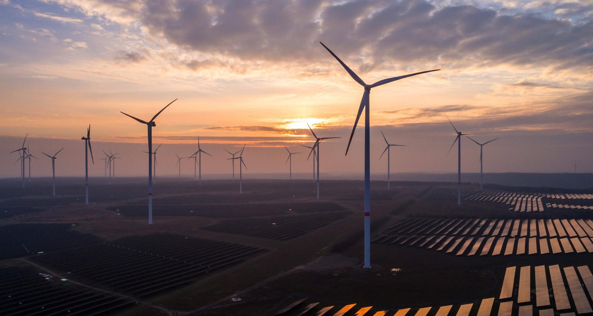 Solaranlagen und Windräder sind im Energiepark Lausitz bei Klettwitz bei Sonnenuntergang zu sehen.
