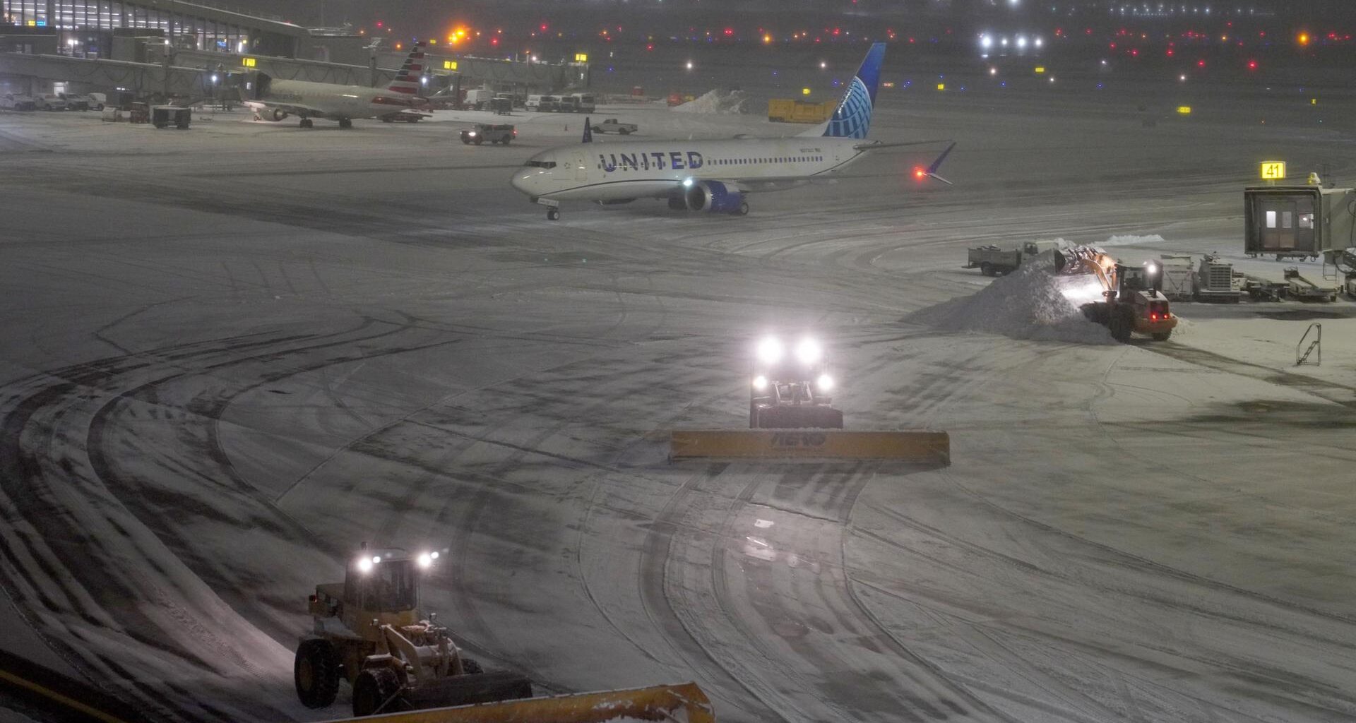 Schneepflüge räumen nachts das Vorfeld auf dem LaGuardia Airport.