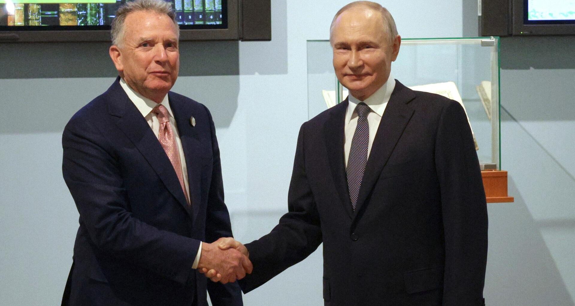 Der US-Sondergesandte Steve Witkoff und Russland Präsident Putin schütteln sich die Hand und blicken dabei in die Kamera.