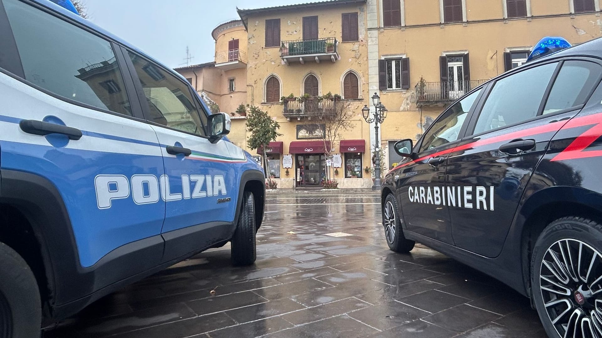 Zwei Autos der italienischen Polizei und der Carabinieri stehen nebeneinander vor einem Gebäude. Zwei Autos der italienischen Polizei und der Carabinieri stehen nebeneinander vor einem Gebäude.