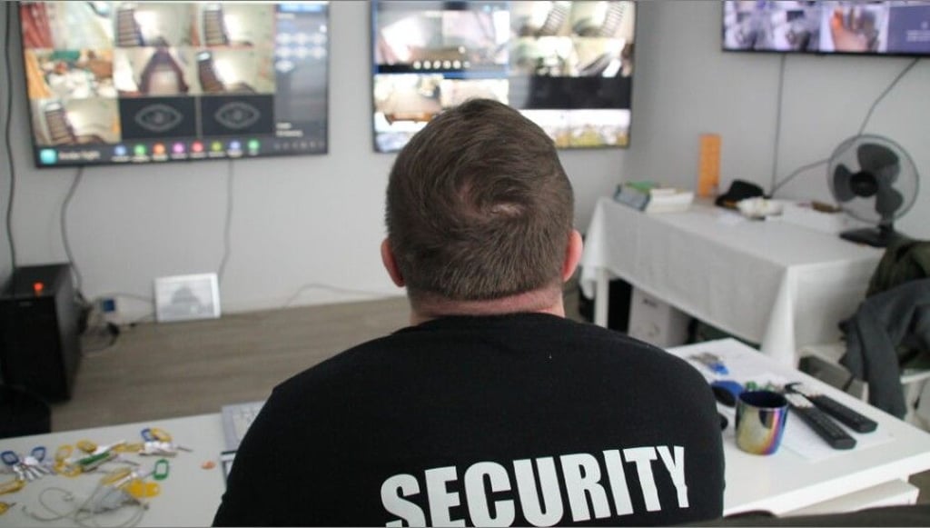 Ein Securitymann überwacht auf mehreren Monitoren die Flure, Treppenhäuser und Eingänge der Flüchtlingsunterkunft.