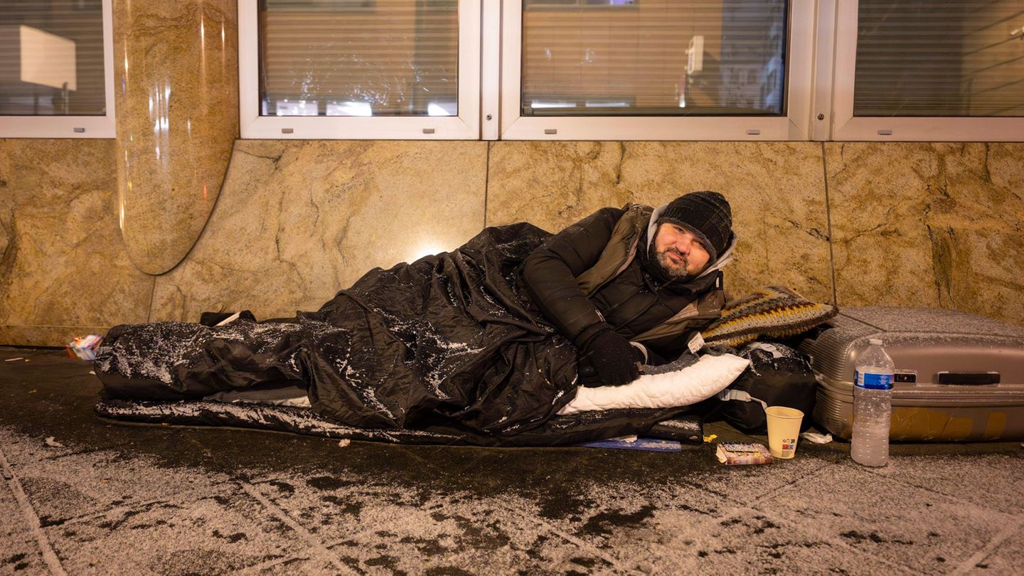 Mit einem Schlafsack schützt sich Andrej gegen die Kälte. Foto: Boris Roessler/dpa