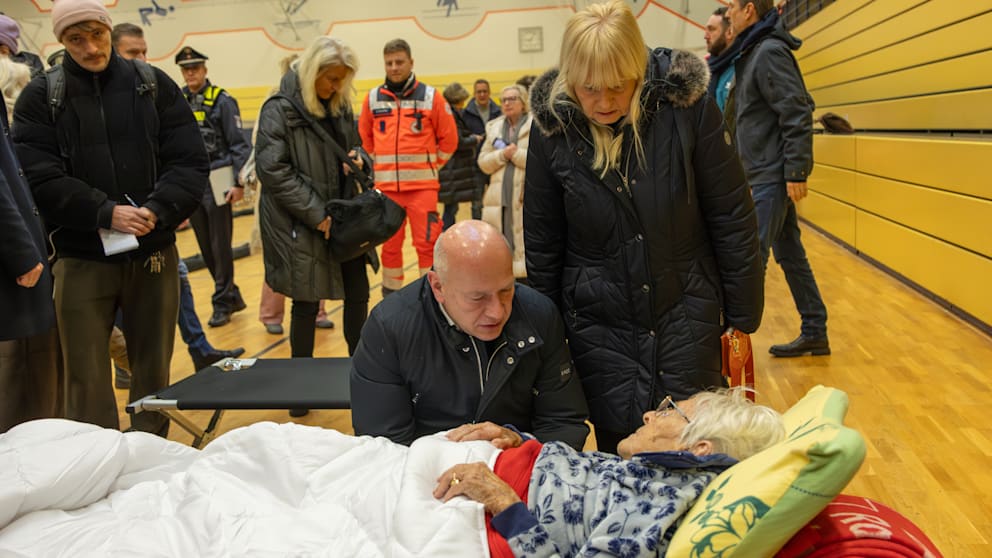 Wegner und Spranger am Feldbett der Pflegebedürftigen Ingeborg Esser, die die Nacht auf einem Feldbett verbringen musste