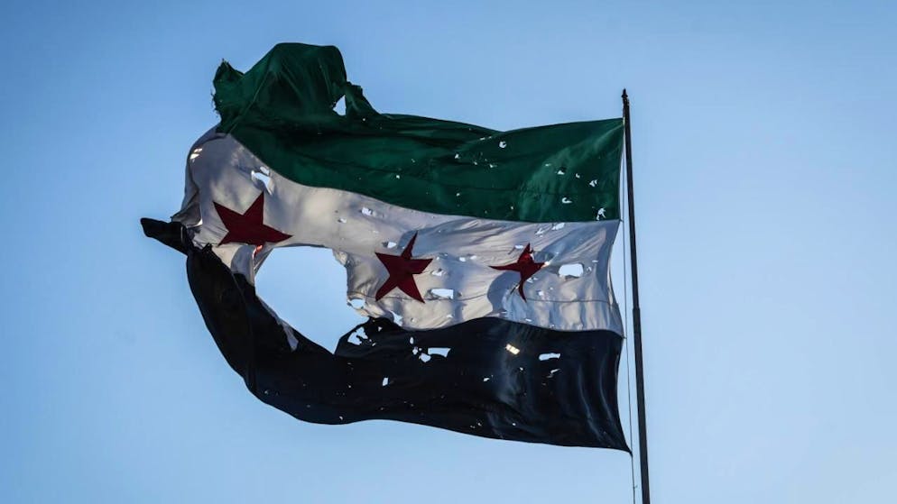 ARCHIV - Eine zerfetzte syrische Flagge weht vor dem syrischen Generalstabshauptquartier. Foto: Moawia Atrash/dpa