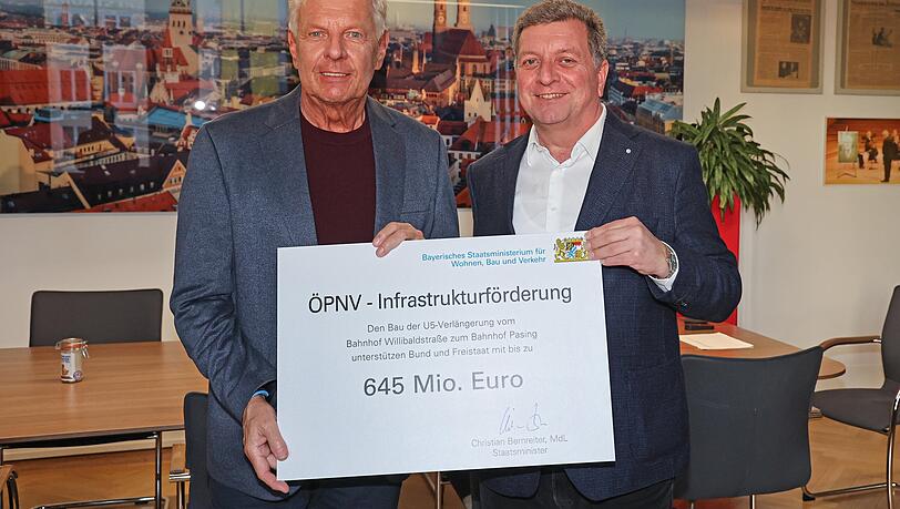 Der bayerische Verkehrminister Christian Bernreiter (rechts) und Münchens Oberbürgermeister Dieter Reiter mit dem symbolischen Förderbescheid für den zweiten Bauabschnitt der U5-Verlängerung vom neuen U-Bahnhof Baumschule Laim bis Pasing Bahnhof.