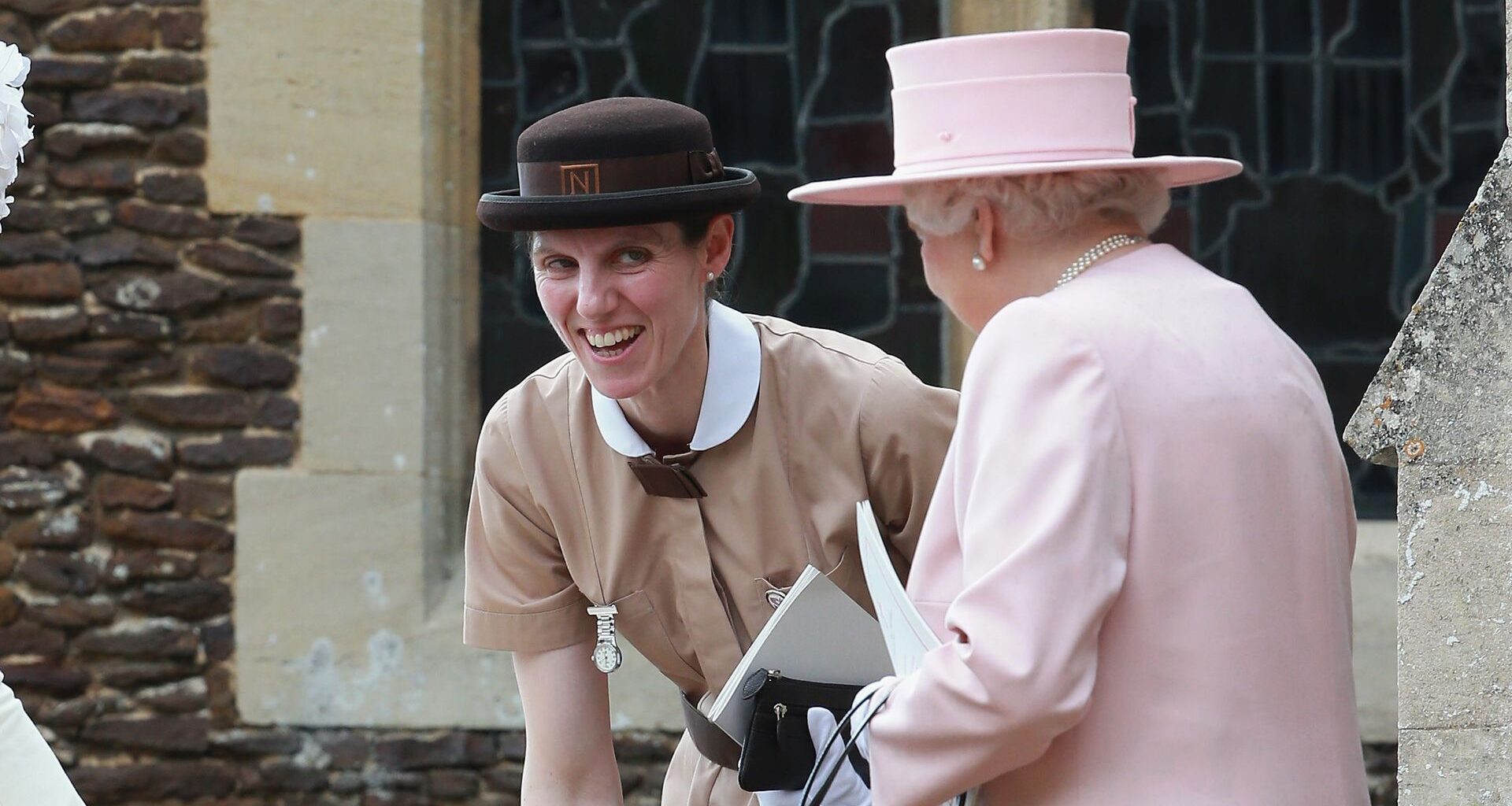 Prinz George spielt am Kinderwagen von Prinzessin Charlotte, während Königin Elizabeth II und Maria Teresa Turrion Borrallo zusehen