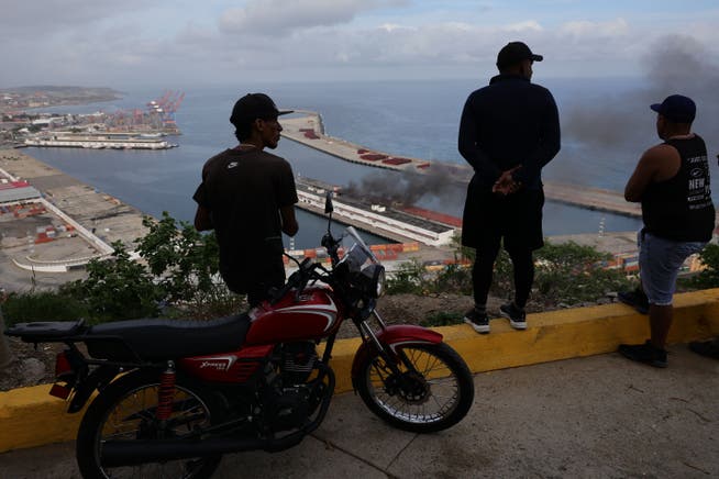 Menschen beobachten Rauch über dem Hafen von La Guaira. US-Präsident Donald Trump erklärte, das US-Militär habe einen Grossangriff gestartet und Präsident Nicolás Maduro festgenommen.