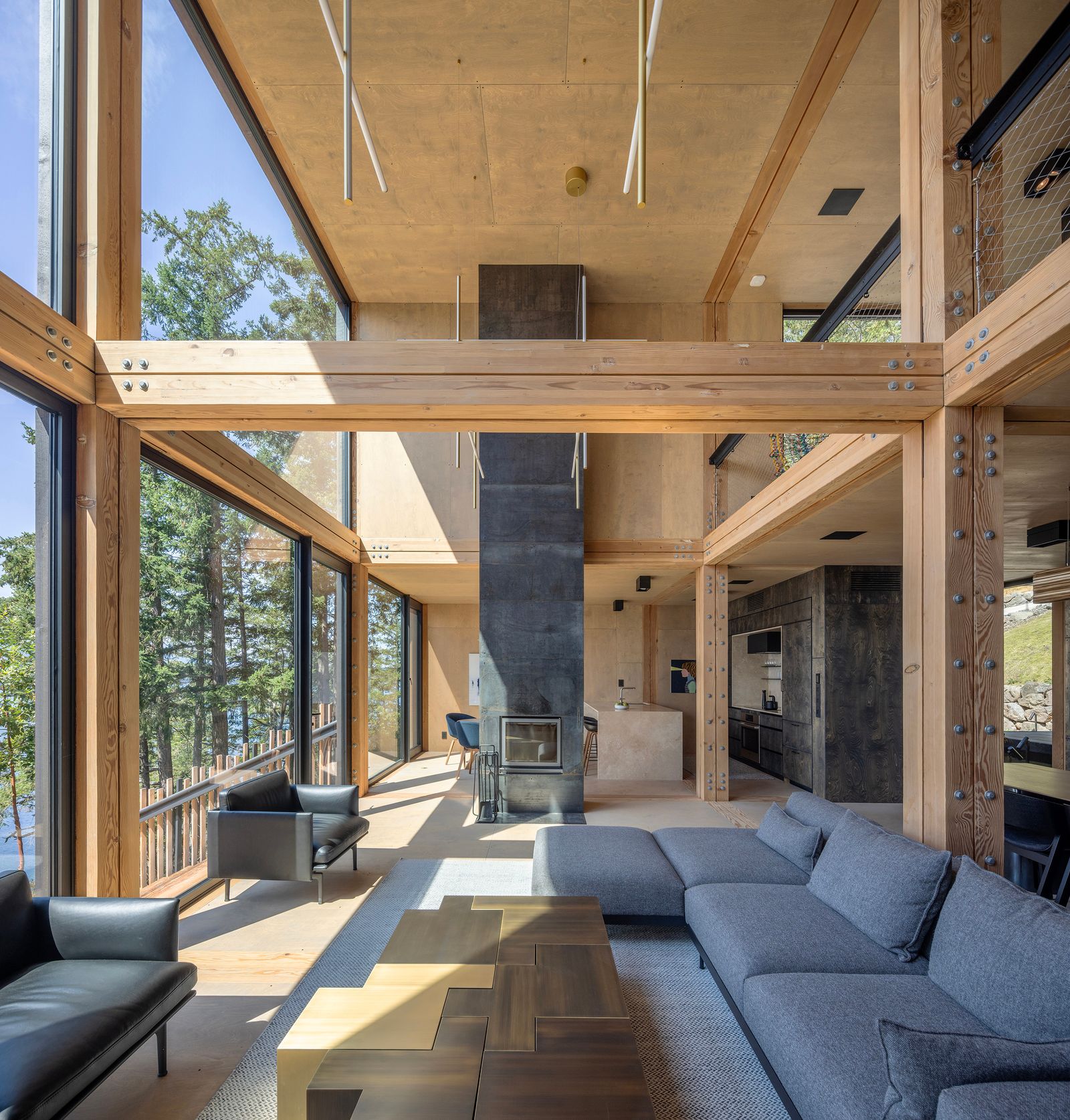 Wohnzimmer Holzwände Balken Sofa Landschaft riesige Fenster Kamin