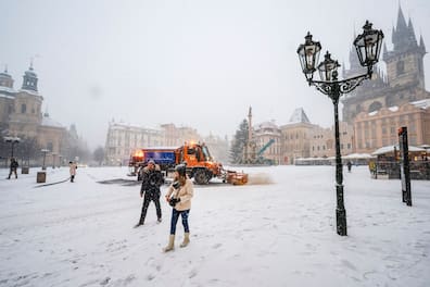 Menschen gehen über den verschneiten Altstädter Ring in Prag