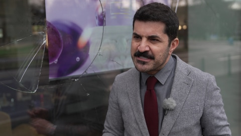 Der Deutsch-Iraner Reza Shari vor dem zertrümmerten Schaufenster seines Schönheitssalons in Mannheim