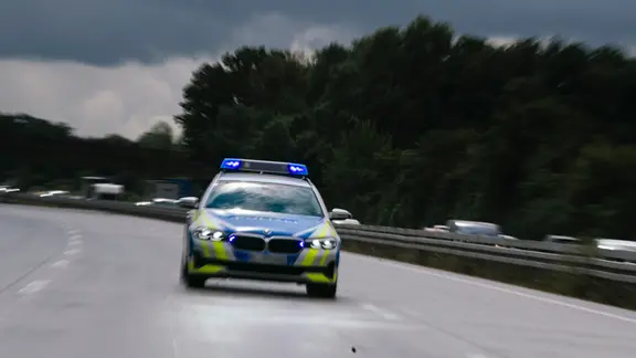 Ein Streifenwagen fährt auf der Autobahn.