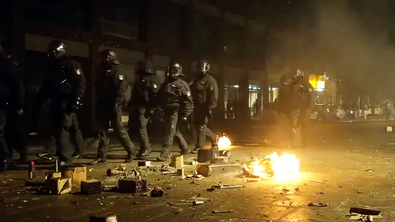 Ein Video-Standbild zeigt Einsatzkräfte der Polizei inmitten von brennender Pyrotechnik im Hamburger Stadtteil Steilshoop