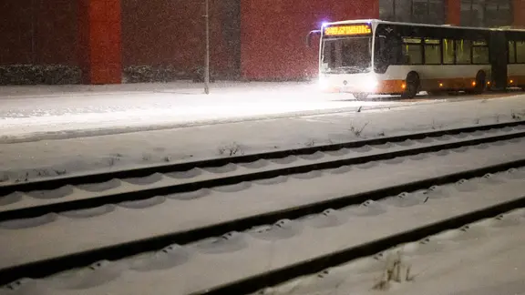 Ein Bus fährt bei Schneefall in der Region Hannover. | dpa, Julian Stratenschulte Ein Bus fährt bei Schneefall in der Region Hannover.
