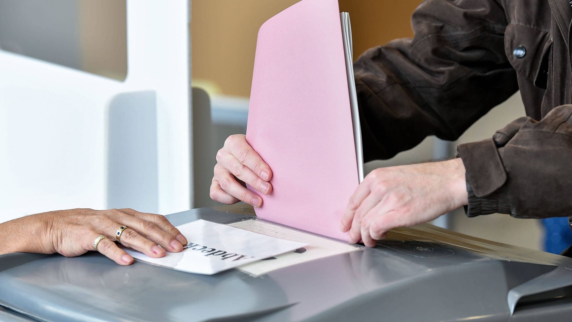 Ein Mann gibt seine Wahlunterlagen ab (Archivbild): In Hessen wird am 15. März gewählt.