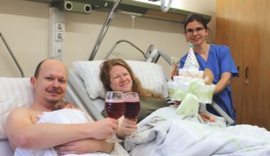 Die Leitende Hebamme Lisa Mühlberg gratuliert den frischgebackenen Eltern mit Brause und einer Windeltorte. Foto: Diako/Victor Franke