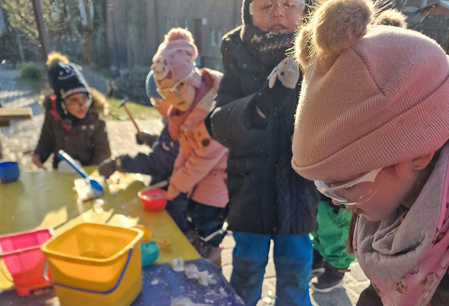 Kinder bearbeiten im Außenbereich Steine.