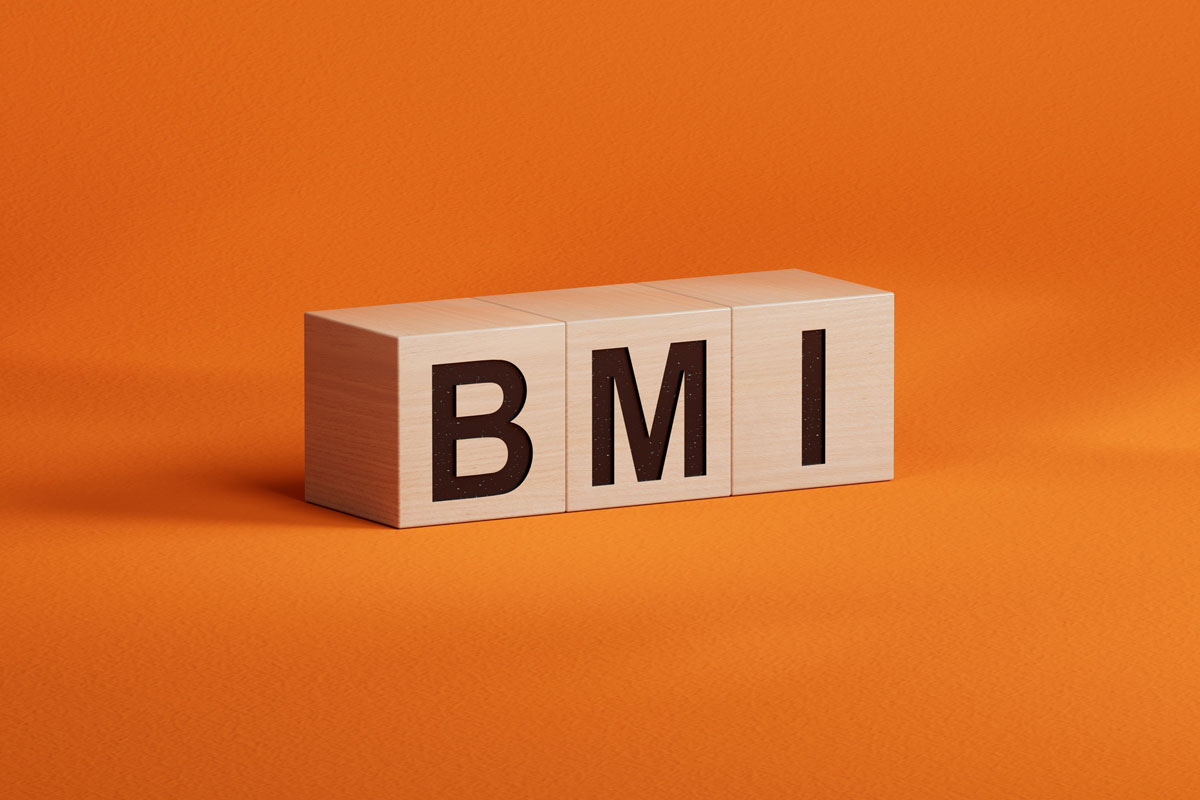 Würfel bilden den Ausdruck BMI (Body Mass Index), der auf orangefarbenem Hintergrund dargestellt wird.