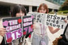Fans der K-Pop-Band BTS halten Schilder in die Höhe, während sie auf den Einlass zum jährlichen 2025 BTS Festa warten, mit dem das Debütjubiläum von BTS in Goyang, Südkorea gefeiert wird.

Die Band BTS hat viele Fans.