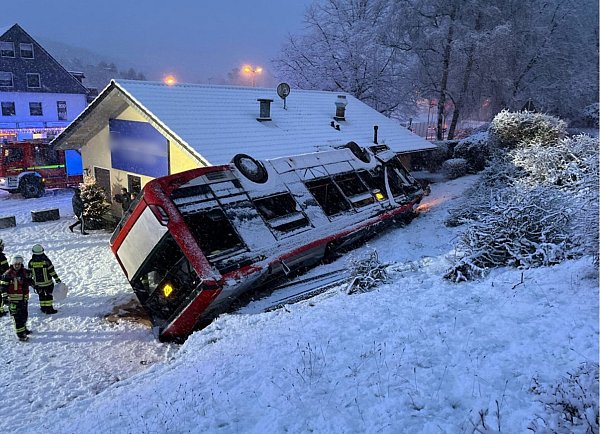 Kürten: Ein Linienbus liegt nach einem Unfall auf dem Dach an einem Haus. - © Polizei Oberbergischer Kreis/dpa