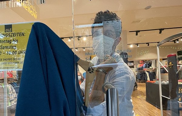 Jack Wolfskin-Manager Alto Torbati zeigte bereits 2021, wie der Täter mit Hilfe einer Drahtangel seine Ware durch den Türspalt gezogen haben muss. - © Stefan Becker