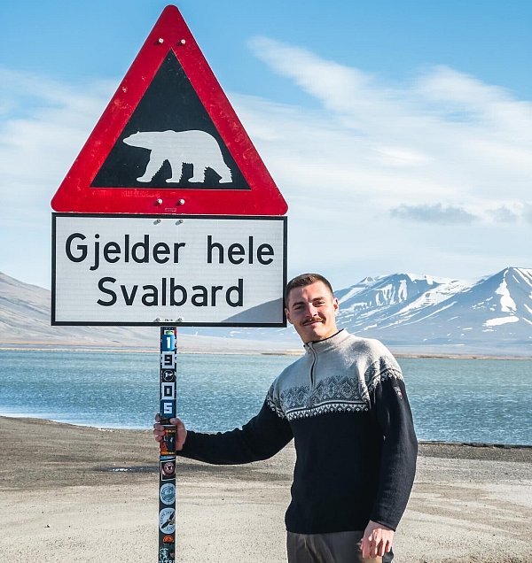 Das Bild von Marius Bensiek ist vor dem berühmten Eisbärenschild in Longyearbyen auf Spitzbergen entstanden. Wenn man genau hinsieht, erkennt man zufällig auch einen Arminia-Sticker auf der Stange. Wie genau der da hingelangt ist, kann sich der Bielefelder auch nicht erklären. - © Privat
