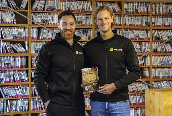 Wayan Rump (links) und Maximilian Buschmeyer mit dem neuen "VanSite"-Stellplatzführer 2026. - © Reise-Know-How-Verlag
