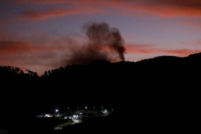 Smoke rises near Fort Tiuna during a full blackout, following explosions and loud noises, after U.S. President Donald Trump said the U.S. has struck Venezuela and captured its President Nicolas Maduro, in Caracas, Venezuela, January 3, 2026. REUTERS/Leonardo Fernandez Viloria