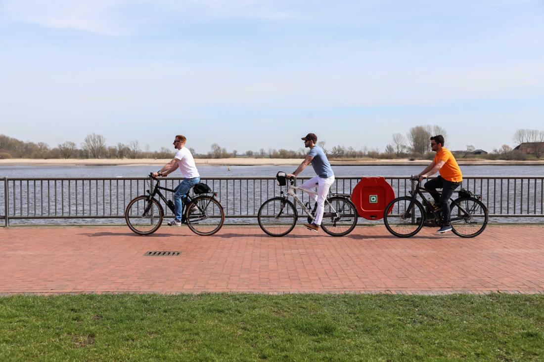 Drei Fahrradfahrer radeln an der Weser in Höhe Brake und Harrier Sand auf dem Elbe-, Weser- und Ems-Radweg in Niedersachsen entlang.