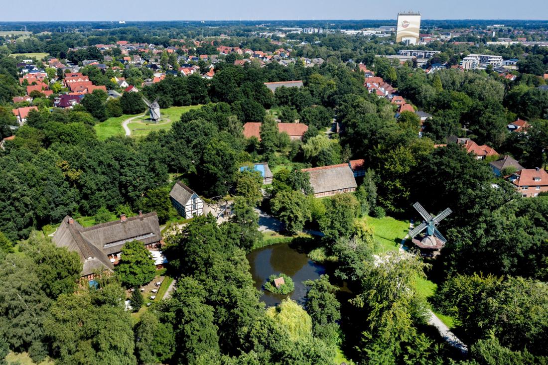 Im „Museumsdorf“ in Cloppenburg stehen in der weitläufigen Parkanlage historische Gebäude, deren Anordnung durch eine Luftaufnahme mit einer Drohne gut erkennbar sind. Das niedersächsische Freilichtmuseum wurde im Jahr 2022 genau 100 Jahre alt.