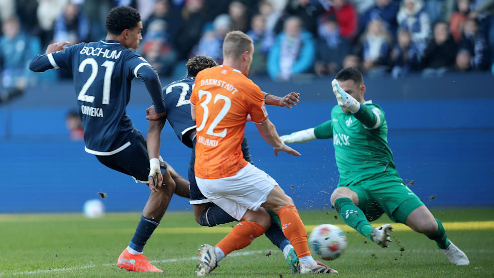 Bochums Francis Onyeka (l.) schaltet schneller als die Darmstädter Fabian Holland (M.) und Keeper Marcel Schuhen (r.), trifft in dieser Szene zum verdienten1:1-Ausgleich