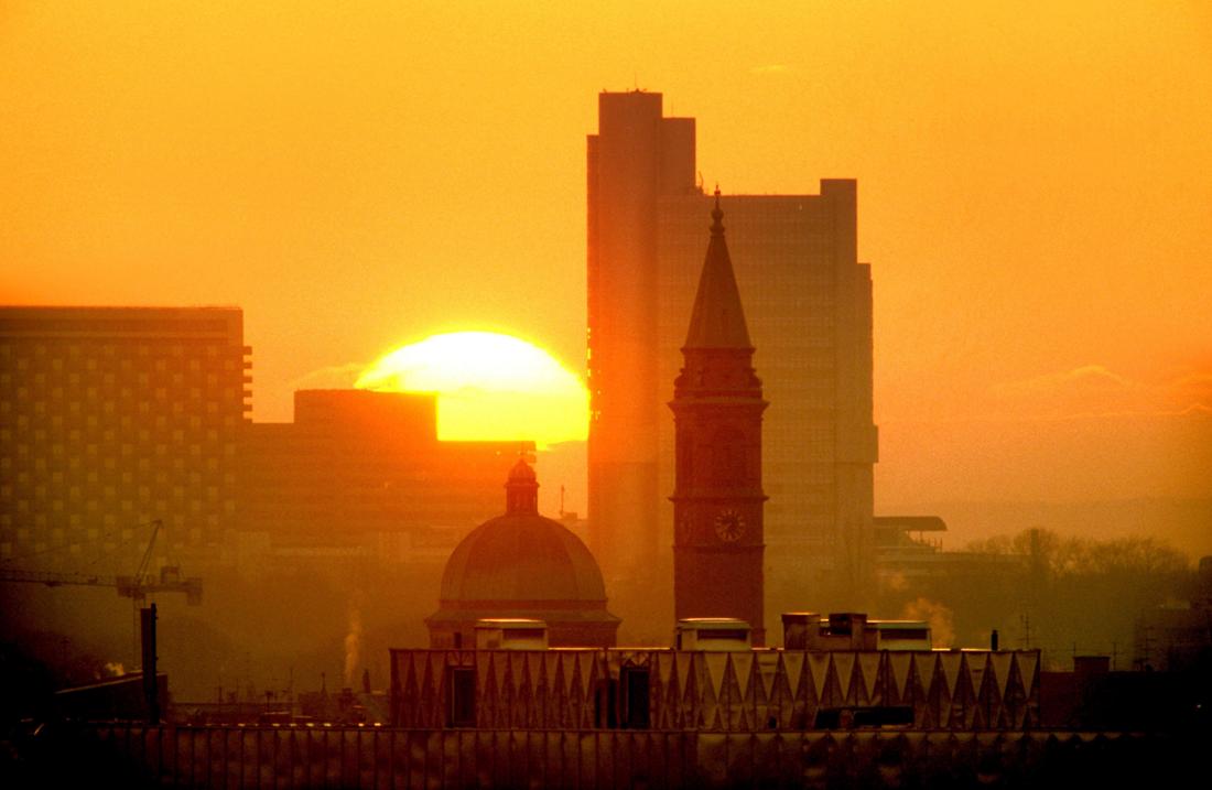 Während Saharastaub in der Luft hängt: Fotograf gelingt spektakuläres Foto eines Sonnenuntergangs hinter der München-Skyline.