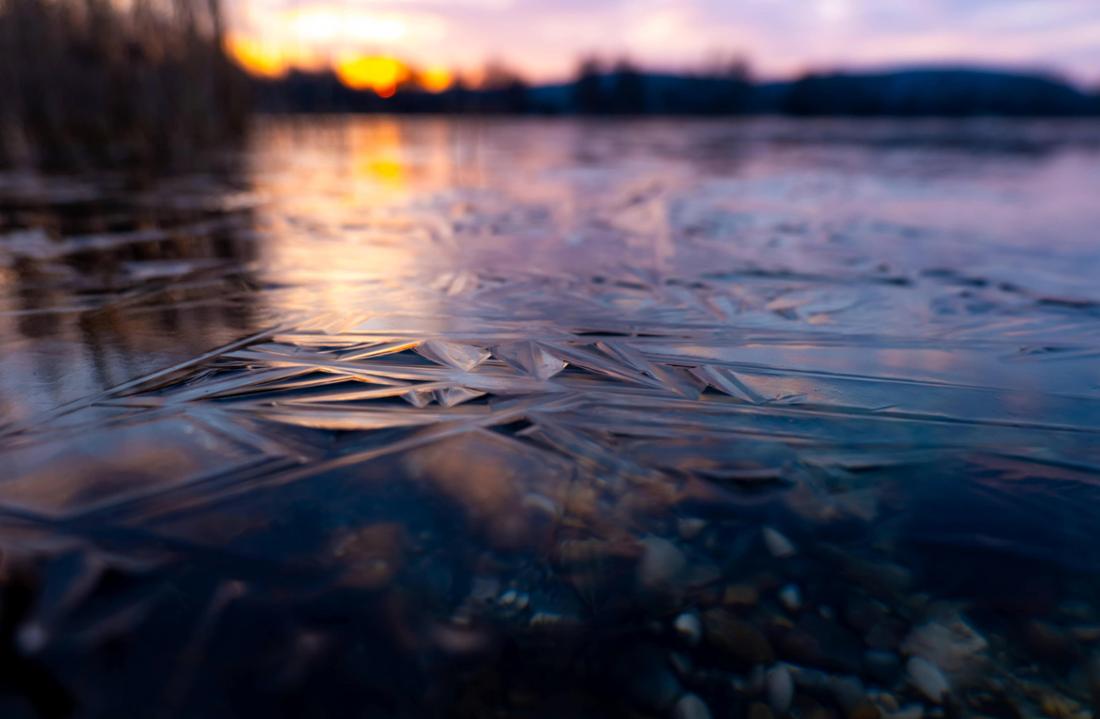 Besondere Nahaufnahme einer gefrorenen Wasseroberfläche eines Weihers in Oberbayern. Aufgenommen am Kranzberger Weiher.