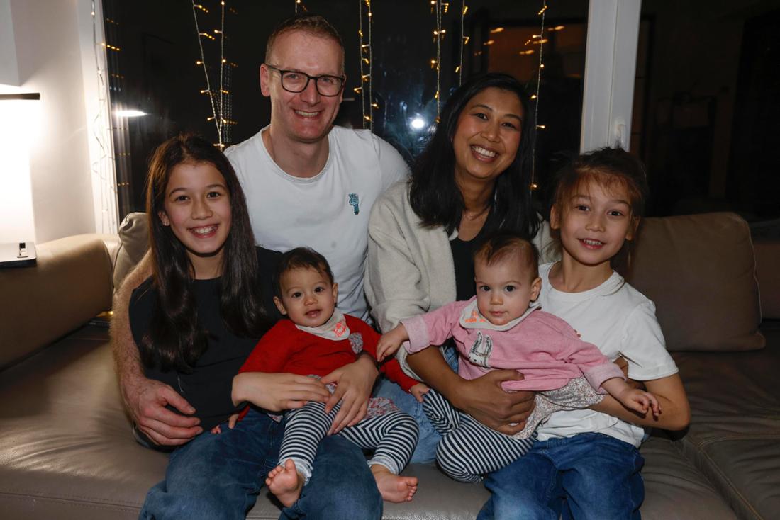 Familie Rachinger mit ihren vier Kindern in ihrem Wohnzimmer in Unterschleissheim, am 15. Dezember, 2025. Papa Andreas (41) und Mama Duongmani (42) mit den Kindern Lilli (10) und Philipp (6) und den Zwillingen Ella und Emma. Kurios: Ella ist vor Mitternacht geboren, Emma nach Mitternacht.