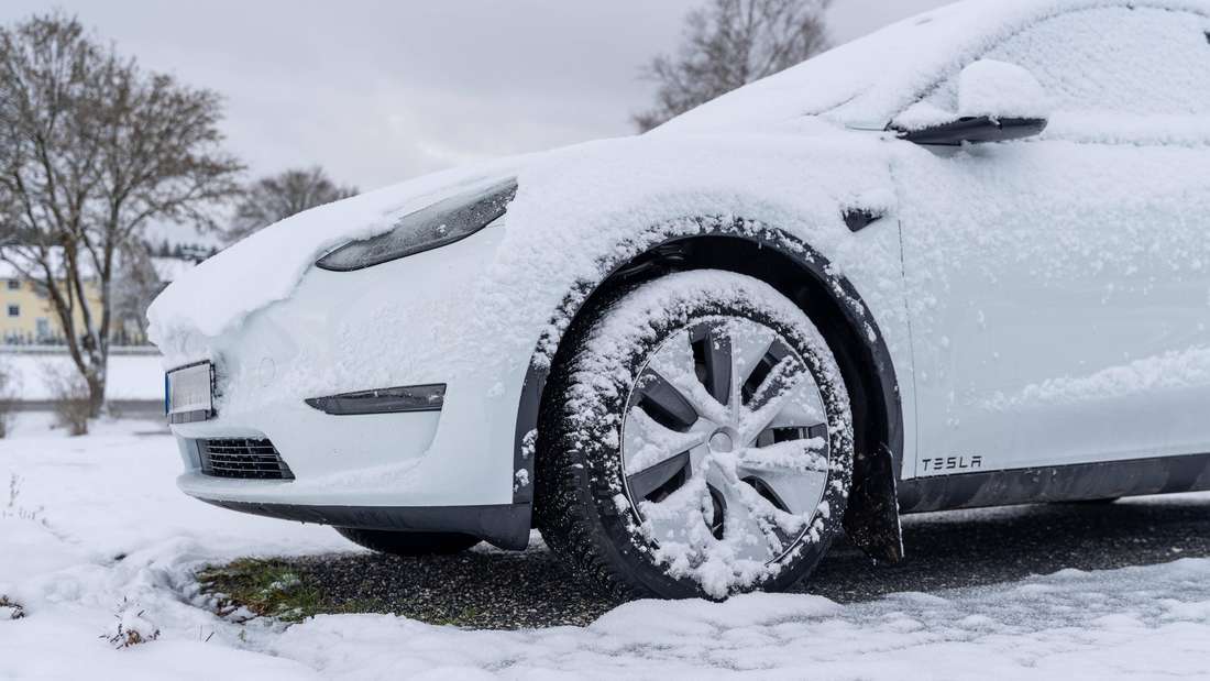 Verschneites Elektroauto bei winterlichen Bedingungen.