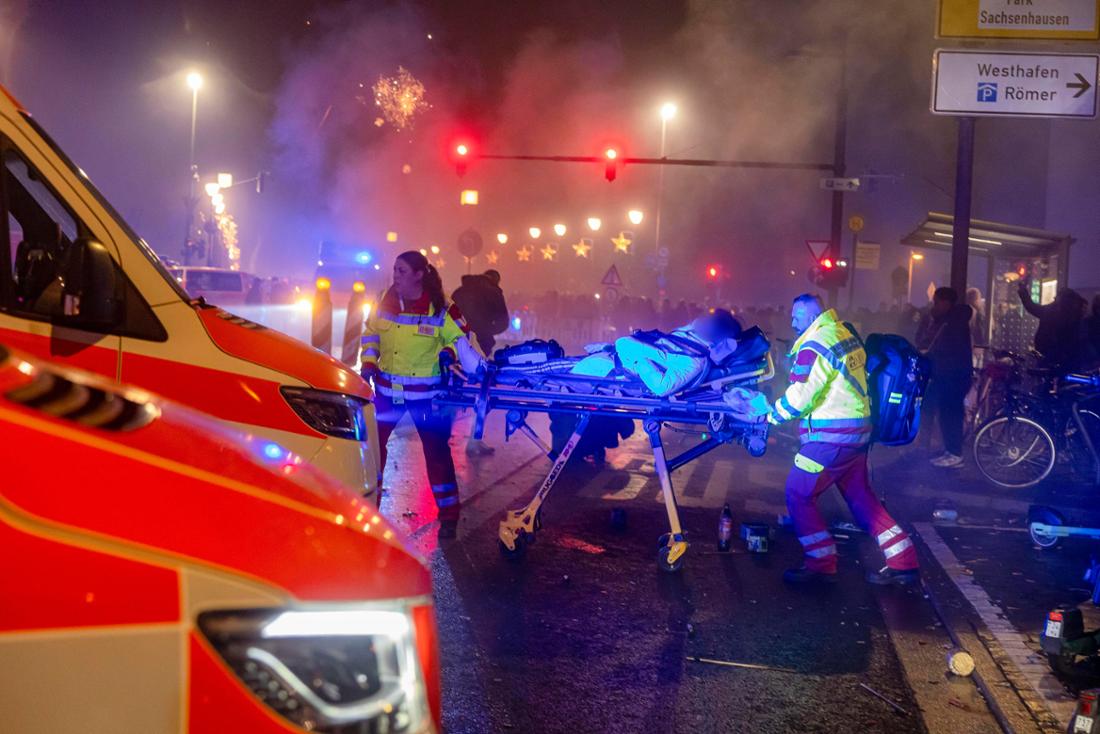 01.01.2026, Hessen, Frankfurt/Main: Eine verletzte Person wird von Sanitätern während des Feuerwerks zum Jahreswechsel am Mainufer abtransportiert. Foto: Helmut Fricke/dpa - ACHTUNG: Person(en) wurde(n) aus rechtlichen Gründen gepixelt +++ dpa-Bildfunk +++