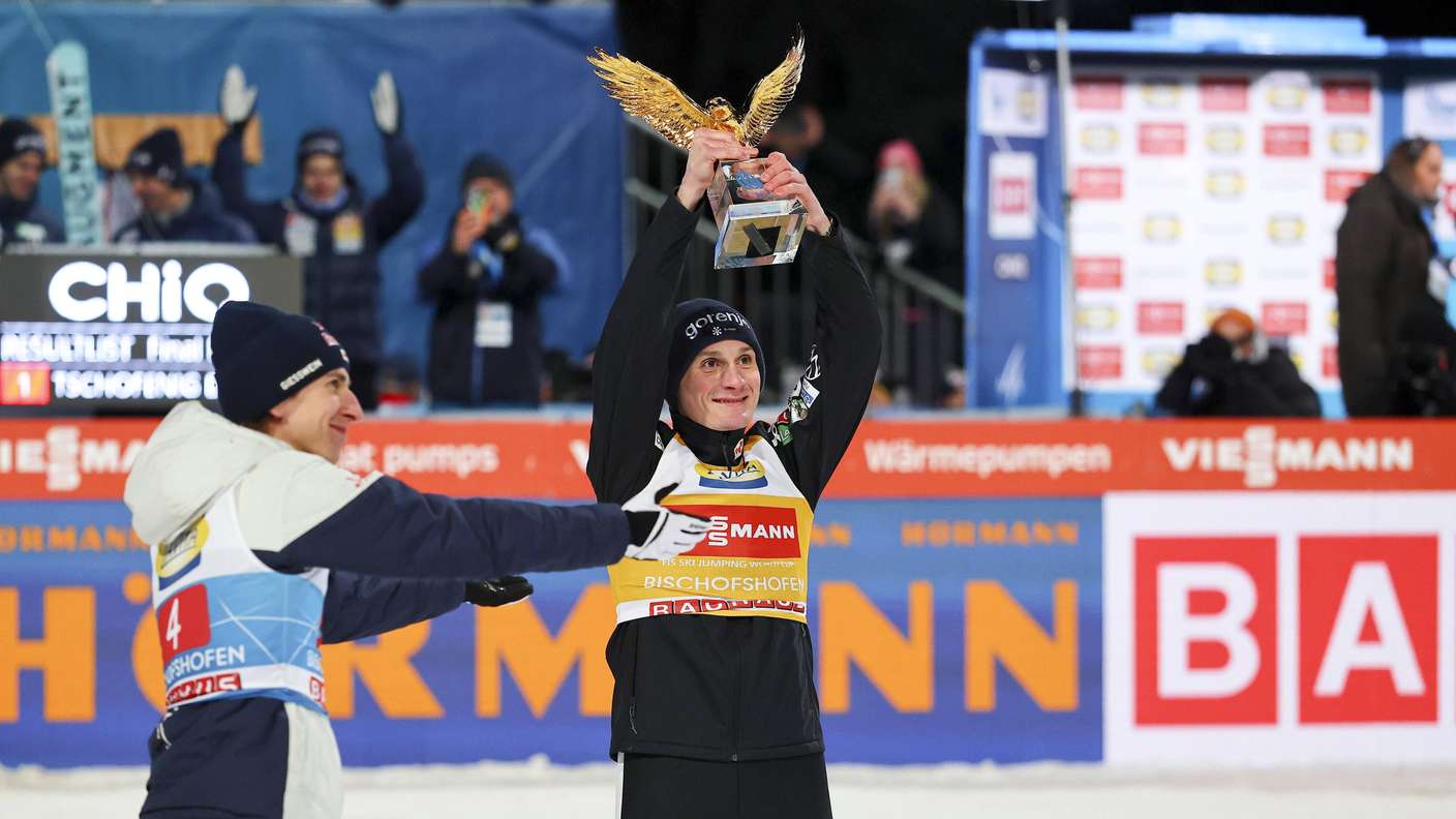 Vierschanzentournee: Vorjahressieger Daniel Tschofenig (l.) überreicht Domen Prevc (r.) den goldenen Adler. 