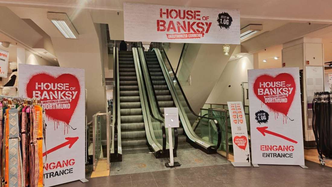 Blick auf die Rolltreppe mit Banksy-Werbung.