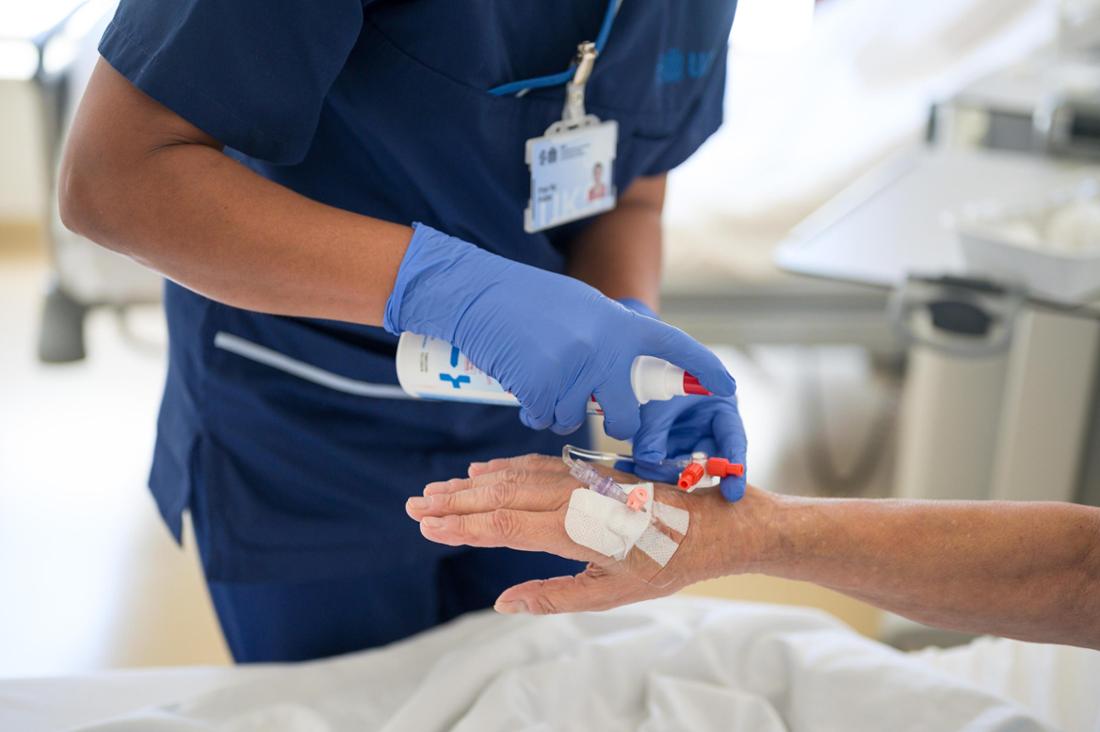 Eine Pflegekraft egt einer Patientin eine Infusion.