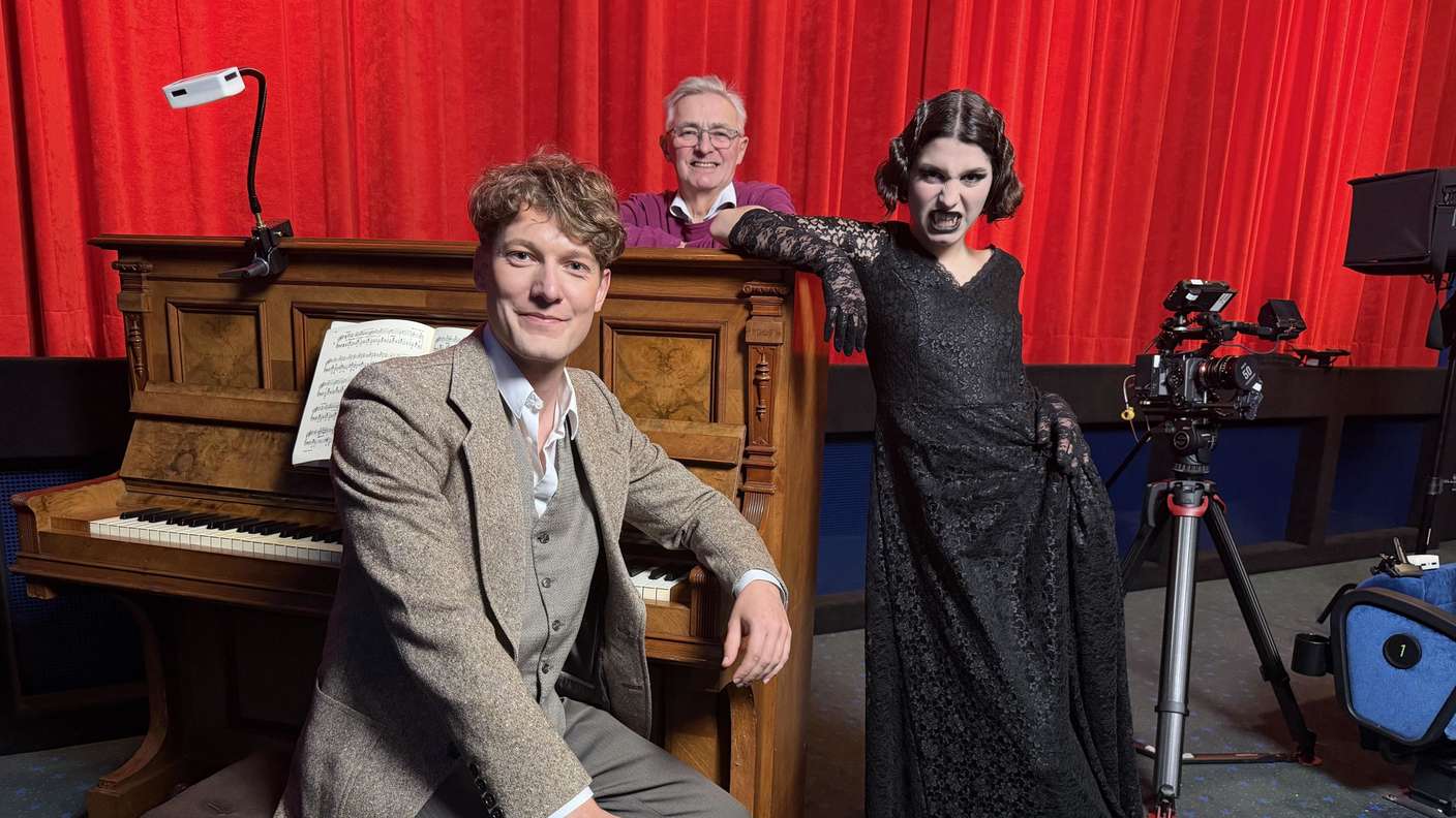 Ein Klavier vor dem roten Vorhang des Kinosaals 2 der Quernheimer Lichtburg mit den Darstellern eines Kurzfilms.