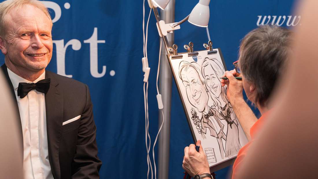 Mit schneller Hand zeichnet Karikaturist RICK humorvolle Porträts der Ballbesucher.