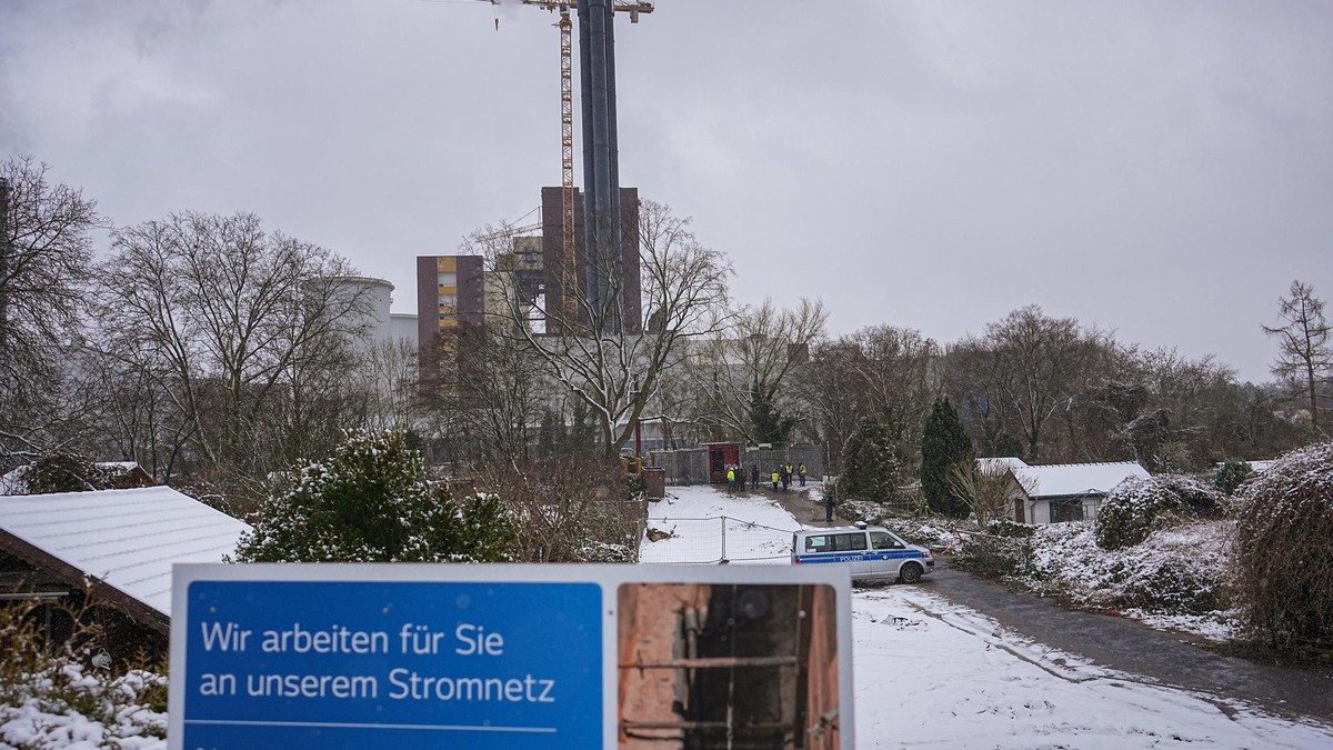 Ein Einsatzfahrzeug der Polizei steht hinter einem Plakat mit der Aufschrift „Wir arbeiten für Sie an unserem Stromnetz“ an der Brandstelle einer Kabelbrücke vor dem Kraftwerk Lichterfelde am Teltowkanal. Stromausfall Berlin