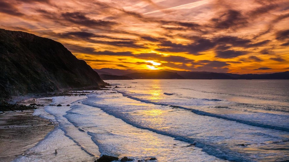 Zur Zeit der Sonnenfinsternis fährt die „AIDAsol“ durch den Golf von Biskaya. Amazing sunset at Barrika beach, Basque Country. Bay of Biscay, Spain