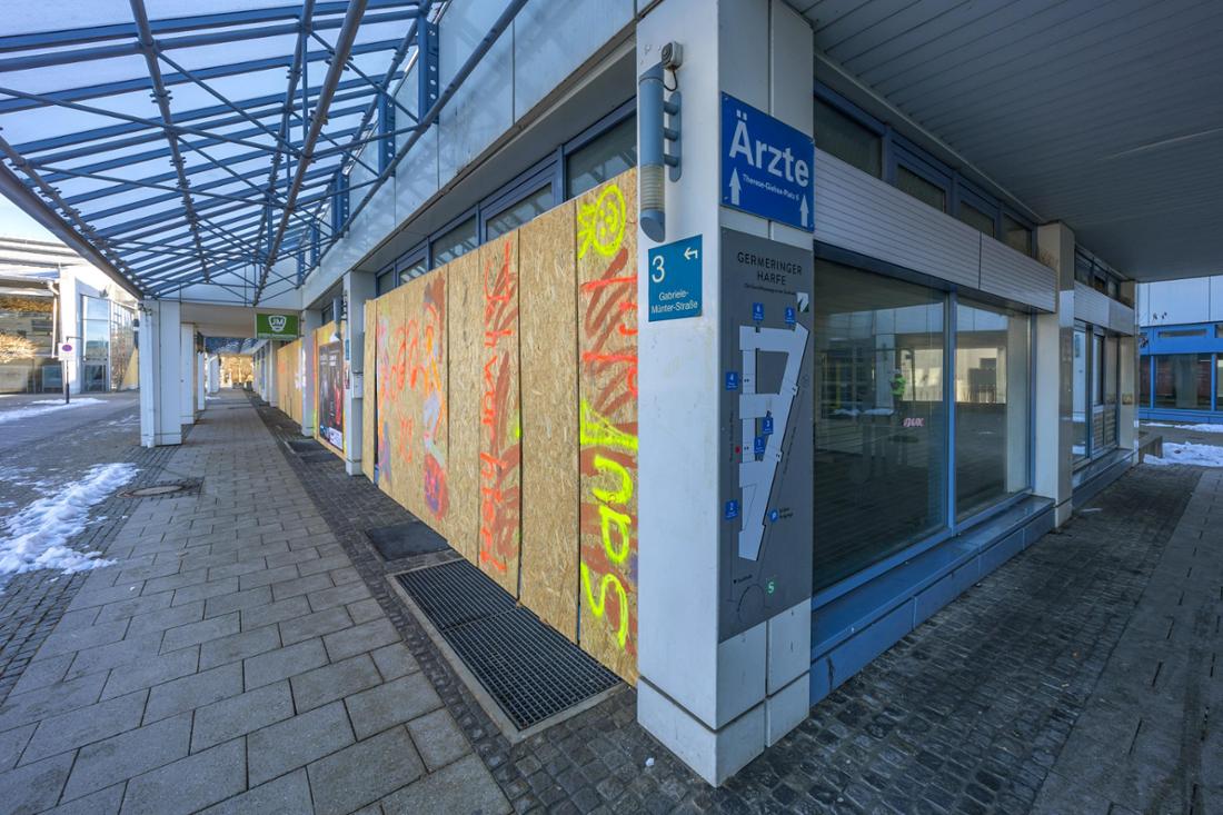 Verrammelte Fenster und Graffiti bestimmen das Bild.