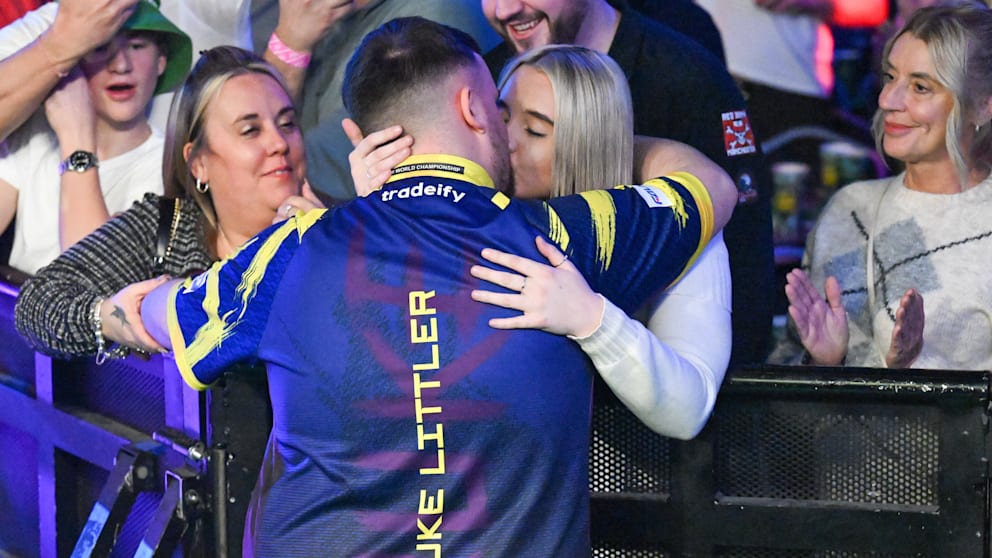 Vor dem Spiel gibt es immer einen dicken Schmatzer von Freundin Faith für ihren Luke. Links neben dem Darts-Star steht seine Mutter