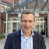 Professor Dr. Sebastian Seitz, der neue Chefarzt am Katholischen Krankenhaus Dortmund-West, steht vor dem Haupteingang der Klinik in Kirchlinde.