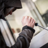 Ein Mann demonstriert, wie Einbrecher Fenster aufhebeln. (Symbolbild)