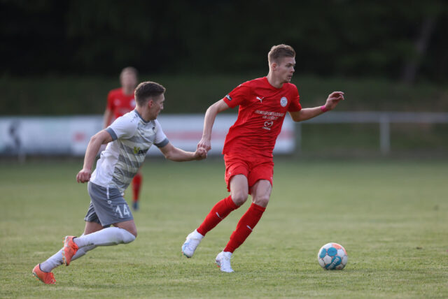 Marvin Schuster dribbelt mit einem Fußball. 