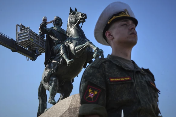 An employee of the Museum of Urban Sculpture cleans a city landmark, the equestrian statue of Peter the Great known as the Bronze Horseman by French sculptor Etienne Maurice Falconet during preparatio ...