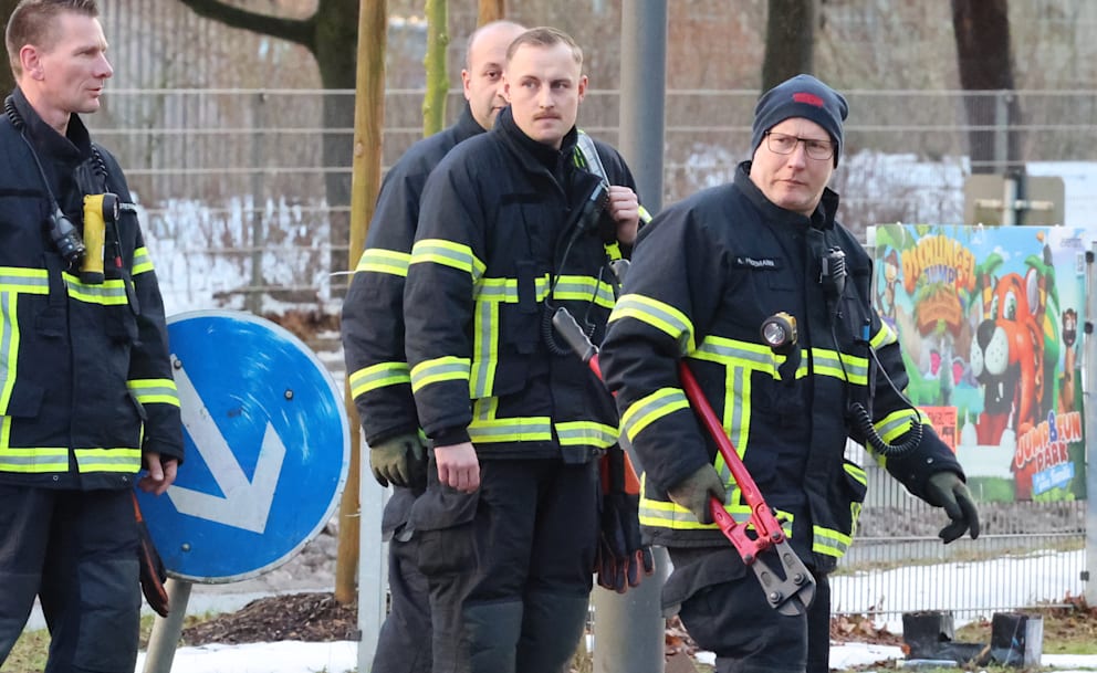 Feuerwehrmänner sind mit dem Bolzenschneider im Einsatz, um damit die Handschellen zu öffnen