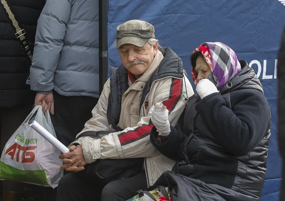 epa12483433 An injured elderly woman on a mobile phone near the site of a Russian strike in Kyiv, Ukraine, 26 October 2025, amid the Russian invasion. At least three people were killed and more than 3 ...